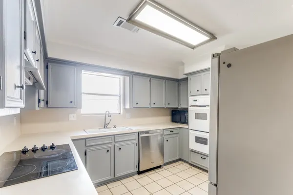 a kitchen with cabinets appliances and a sink