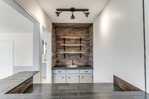 a kitchen with white cabinets and wooden floor