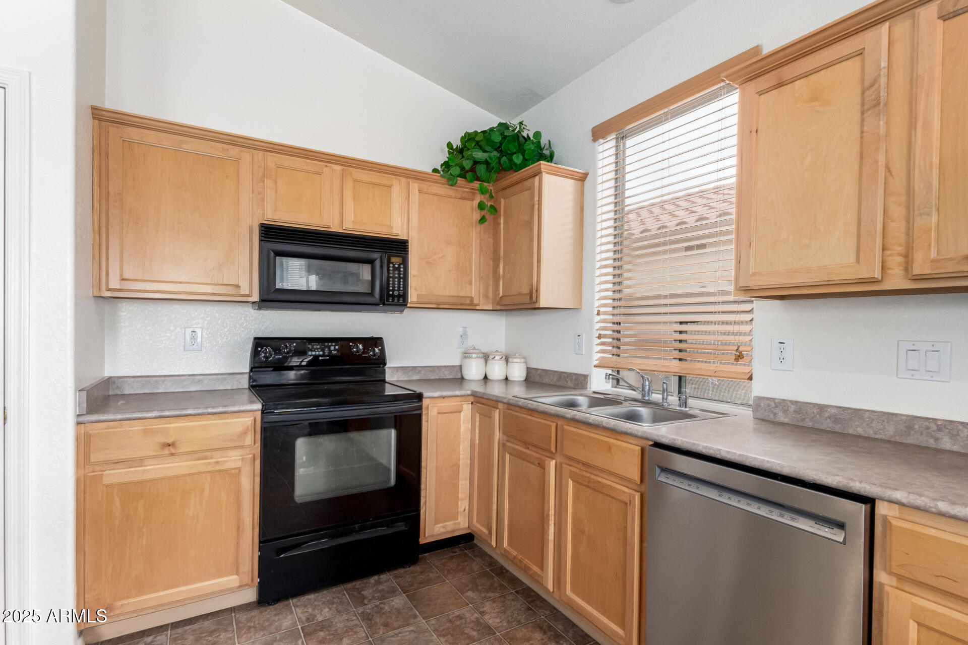 18131 West Addie Lane Surprise, AZ 85374 - Photo 15 of 31 a kitchen with stainless steel appliances granite countertop a sink a stove a microwave and wooden cabinets
