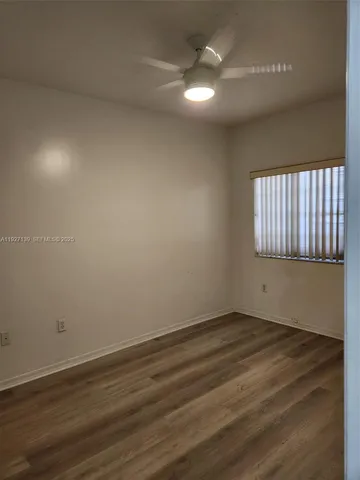 an empty room with wooden floor & closet area
