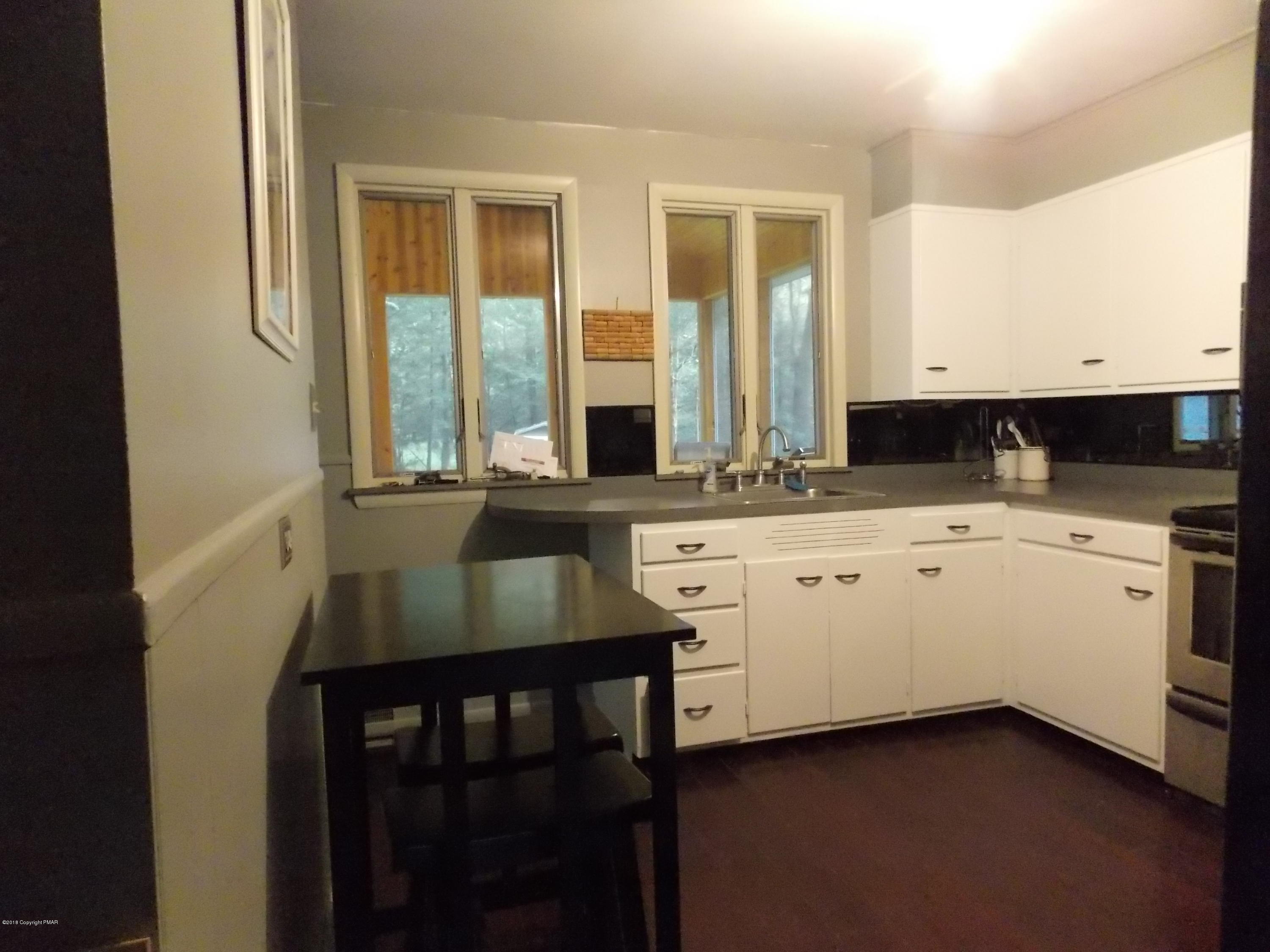 184 Oak Lane Cresco, PA 18326 - Photo 14 of 39 a kitchen with granite countertop white cabinets and white appliances