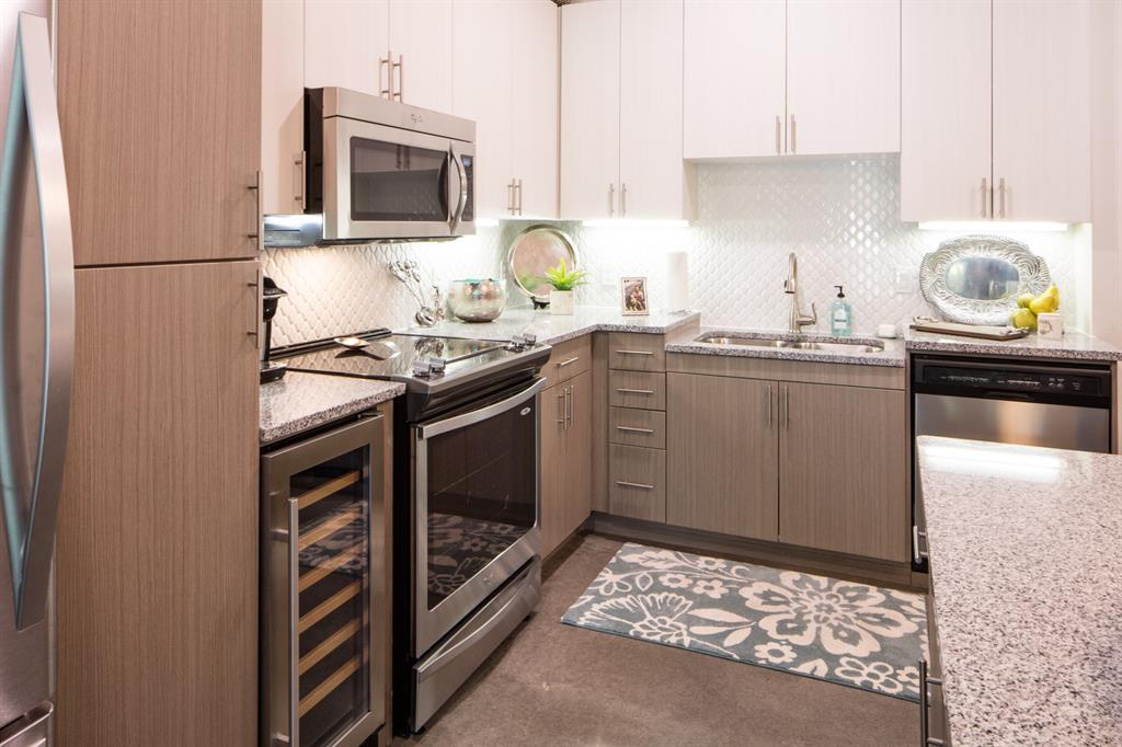 7518 Eastern Avenue, Unit 305 Dallas, TX 75209 - Photo 6 of 7 a kitchen with stainless steel appliances granite countertop a stove a sink and a refrigerator