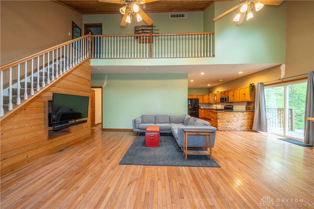 10584 New Biddinger Road Harrison, OH 45030 - Photo 17 of 61 This expansive open-concept living area features a grand staircase and a functional kitchen, ideal for entertaining.