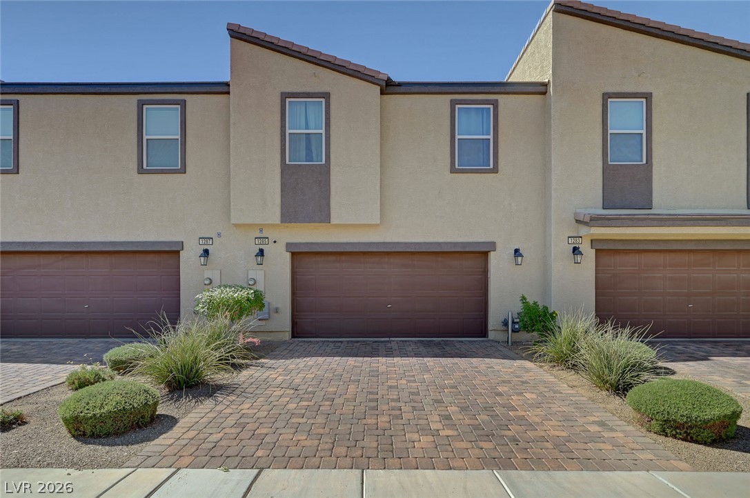 1285 Raritan Place Henderson, NV 89002 - Photo 1 of 20 A paved driveway leads to the attached garage of this contemporary multi-level stucco home.