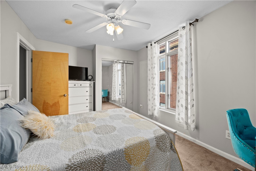 2222 Detroit Avenue, Unit 519 Cleveland, OH 44113 - Photo 20 of 30 Master bedroom featuring a closet, a ceiling fan, baseboards, and carpet floors