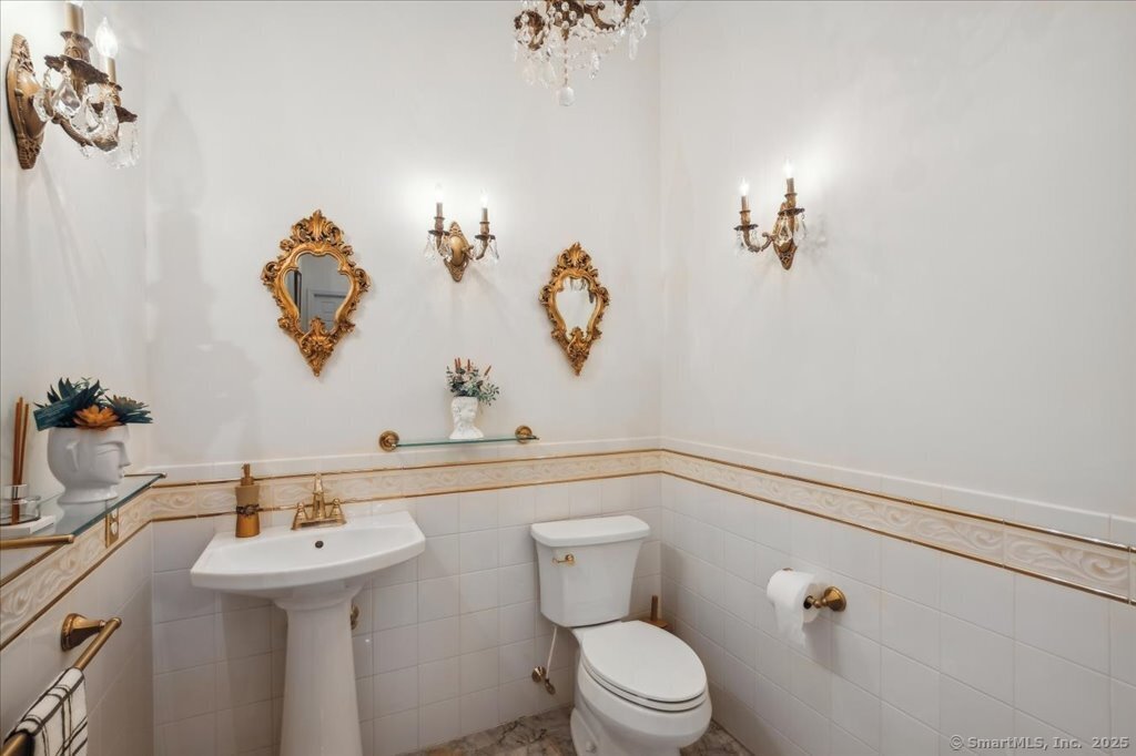 24 Hunting Ridge Drive Simsbury, CT 06070 - Photo 35 of 39 a bathroom with a sink a toilet and mirror