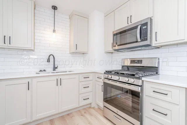 a kitchen with cabinets appliances and a sink