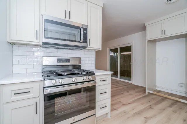 a kitchen with stainless steel appliances granite countertop a stove and a microwave