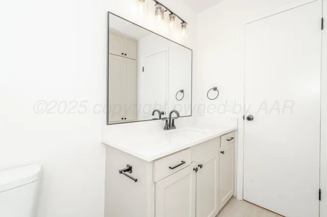 a bathroom with a sink a mirror and a toilet