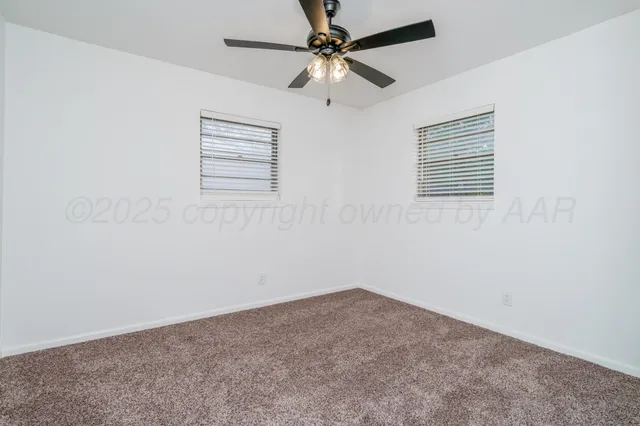 an empty room with a window and a ceiling fan