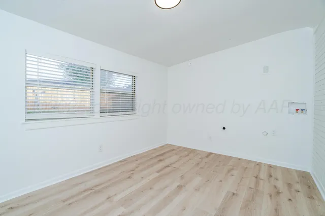 a view of a room with wooden floor and windows