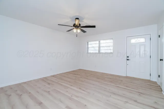 an empty room with fan and windows