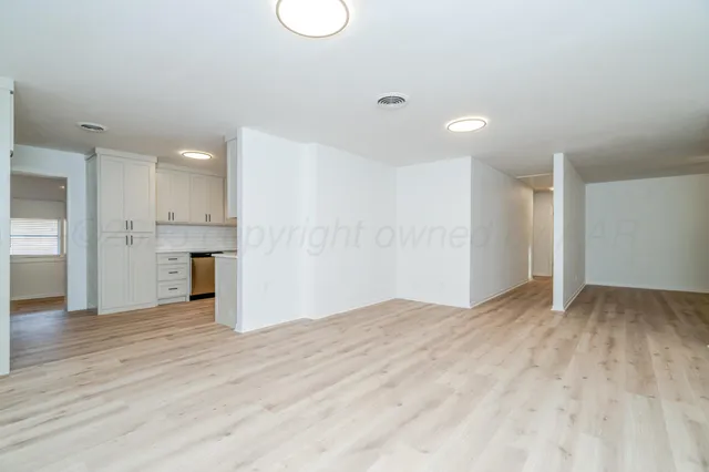 a view of empty room with wooden floor and window