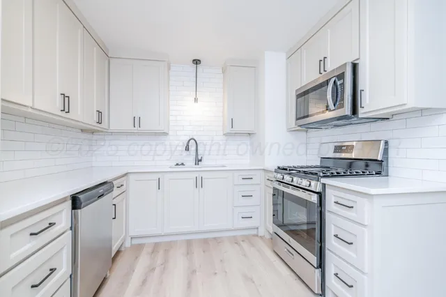 a kitchen with cabinets stainless steel appliances and a sink