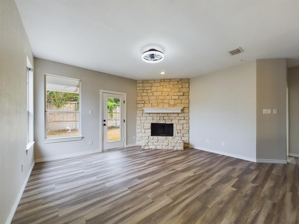 417 Indian Trail Road Roanoke, TX 76262 - Photo 10 of 19 an empty room with wooden floor and a fireplace