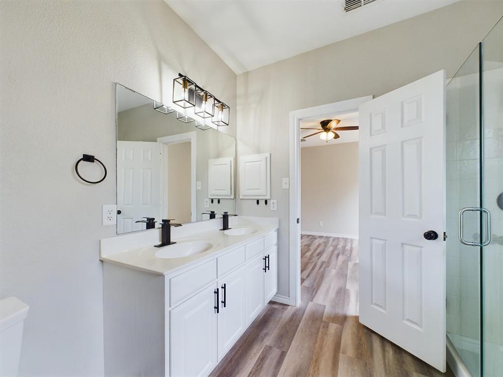 417 Indian Trail Road Roanoke, TX 76262 - Photo 14 of 19 a bathroom with a double vanity sink and mirror