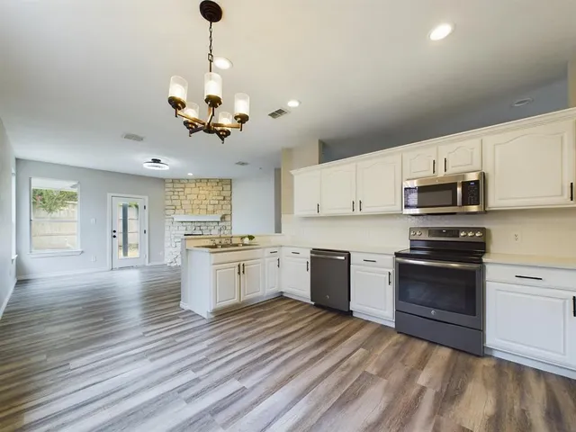 an empty room with wooden floor and a ceiling fan