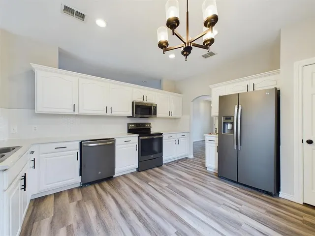 a open kitchen with stainless steel appliances granite countertop a stove and cabinets