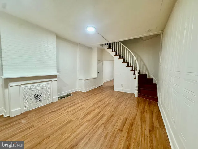 a view of a hallway with wooden floor and staircase