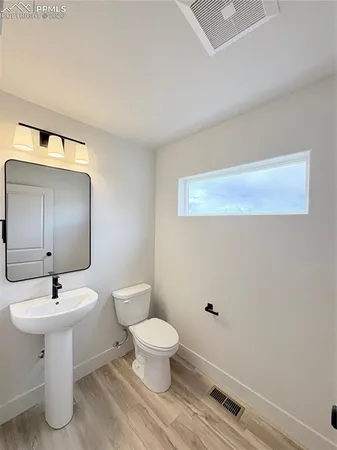 a bathroom with a sink a toilet and mirror