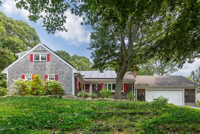 a view of a house with a yard and potted plants