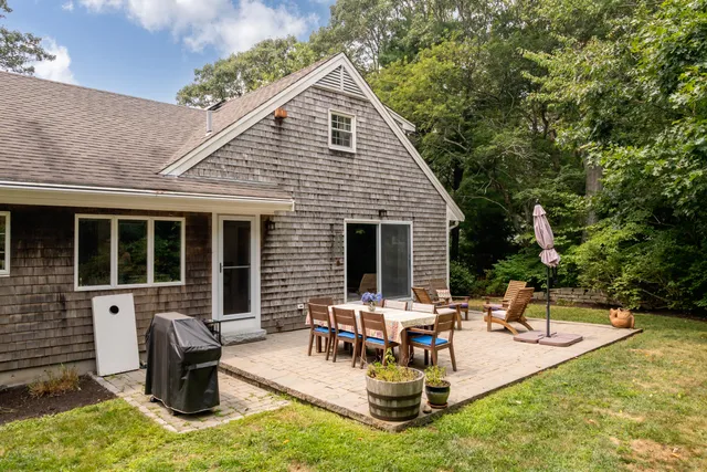 a bedroom with a bed a table and a dresser next to a window