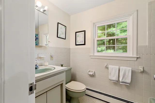 a room with a bed and a flat tv screen on the dresser