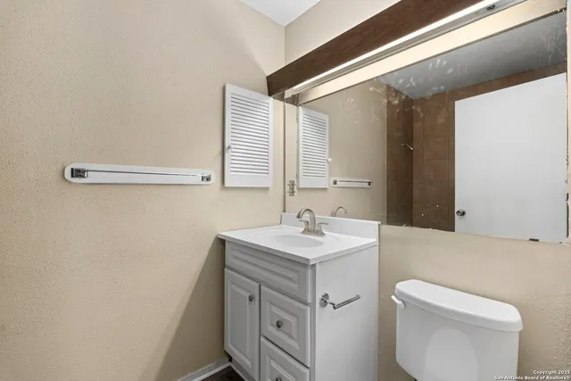 a bathroom with a sink a toilet and a mirror