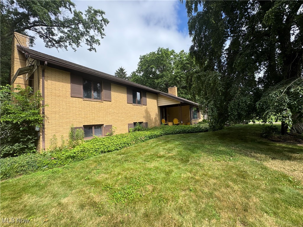 1452 Avalon Road Wooster, OH 44691 - Photo 1 of 31 View of home's exterior featuring a chimney, a lawn, and brick siding