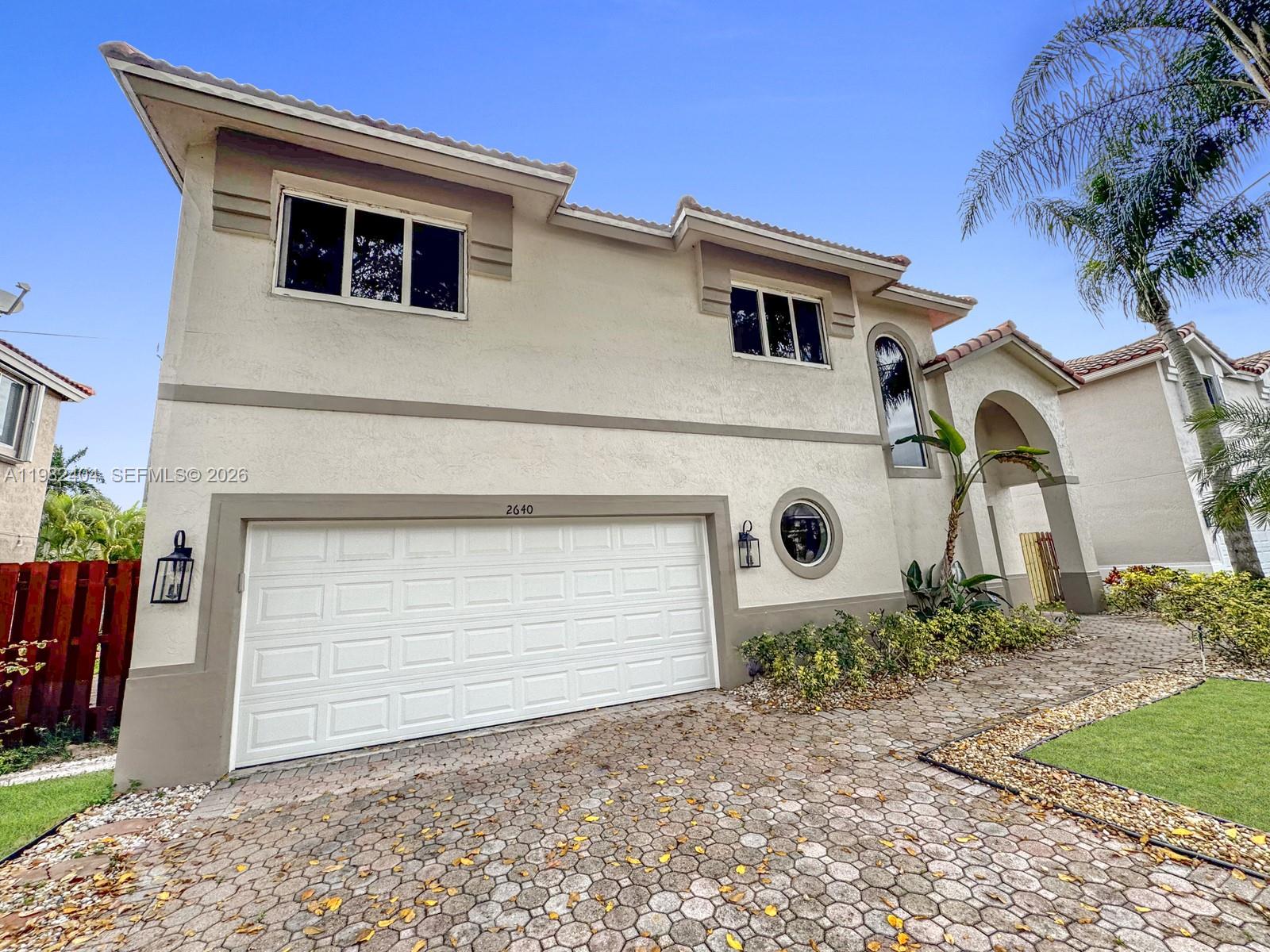 2640 Rampart Way North Cooper City, FL 33026 - Photo 2 of 58 a front view of a house with garden