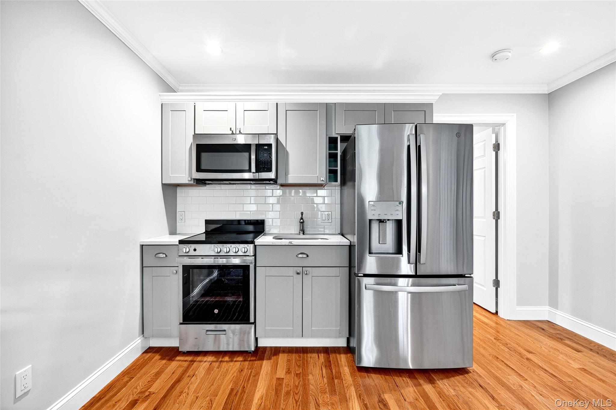 a kitchen with stainless steel appliances a stove microwave and refrigerator