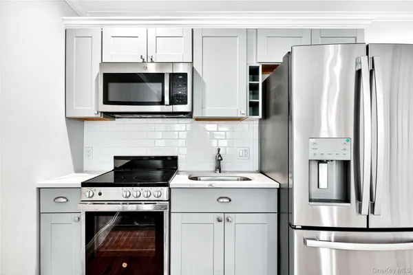 a kitchen with stainless steel appliances a stove microwave and refrigerator