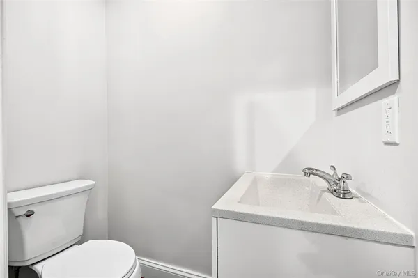 a bathroom with a sink a toilet and mirror