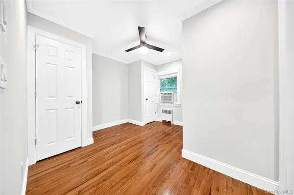 a view of empty room with wooden floor