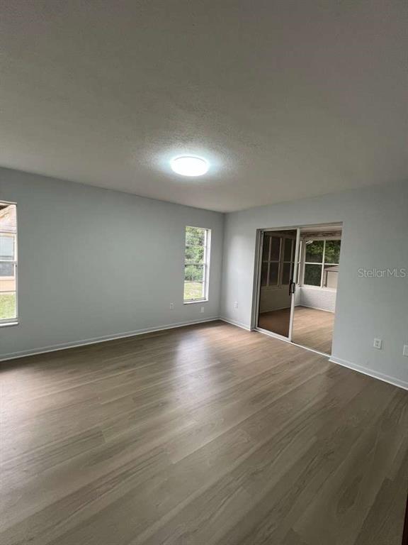 6206 Dorset Road Spring Hill, FL 34608 - Photo 4 of 9 an empty room with wooden floor and windows