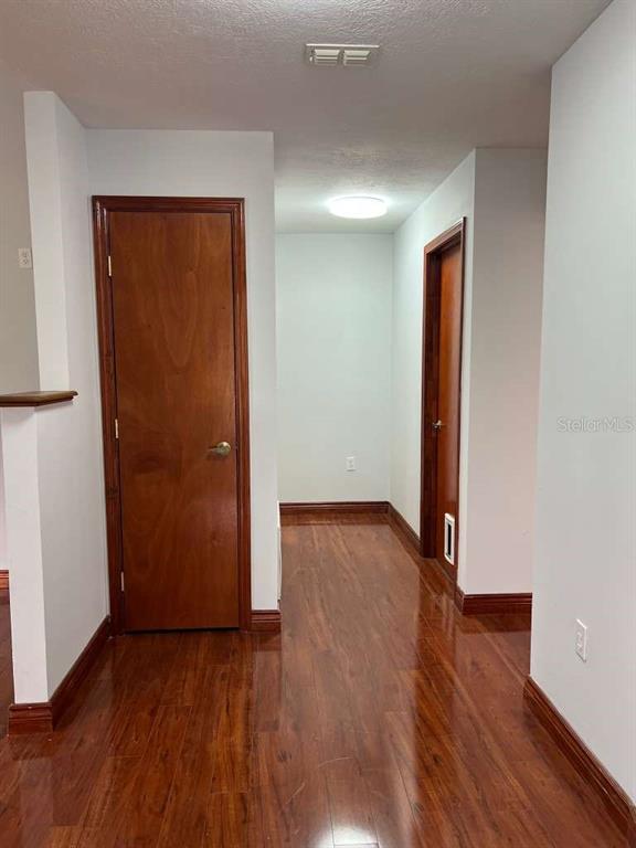 6206 Dorset Road Spring Hill, FL 34608 - Photo 7 of 9 an empty room with wooden floor and entrance