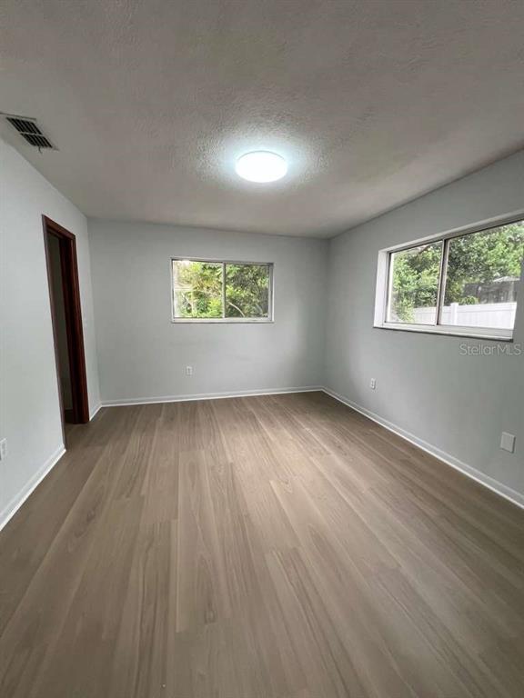6206 Dorset Road Spring Hill, FL 34608 - Photo 9 of 9 an empty room with wooden floor and windows