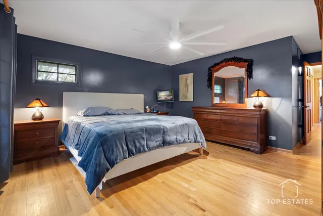 a bedroom with a bed and a lamp on dresser