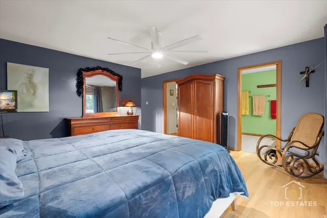 a bedroom with a bed and dresser with mirror