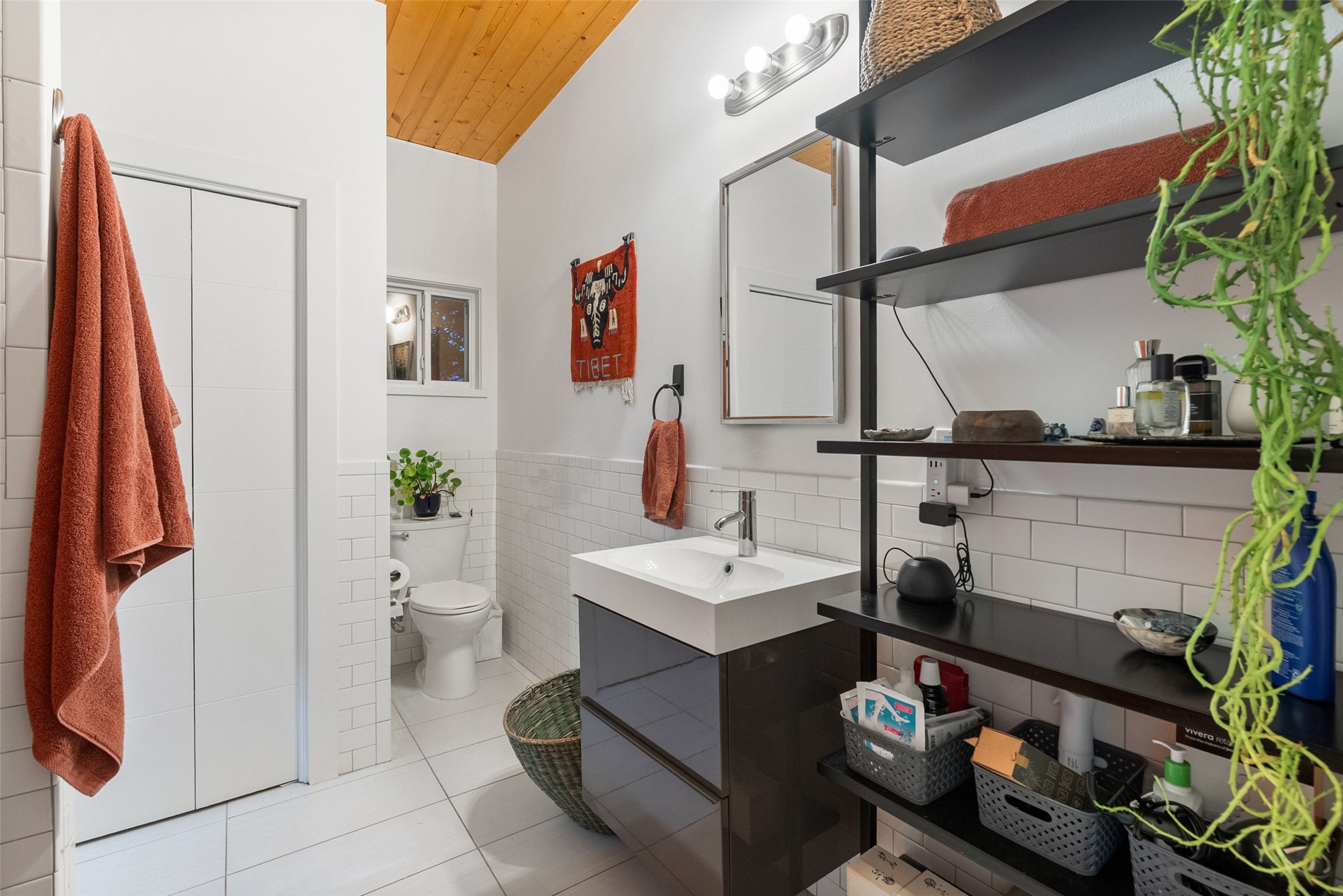 412 West Croslin Street Austin, TX 78752 - Photo 32 of 36 A bright bathroom with a vaulted wooden ceiling and sleek modern vanity.