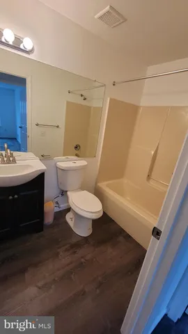 a bathroom with a sink a toilet a mirror and shower