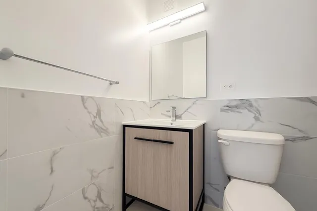 a bathroom with a toilet sink and mirror