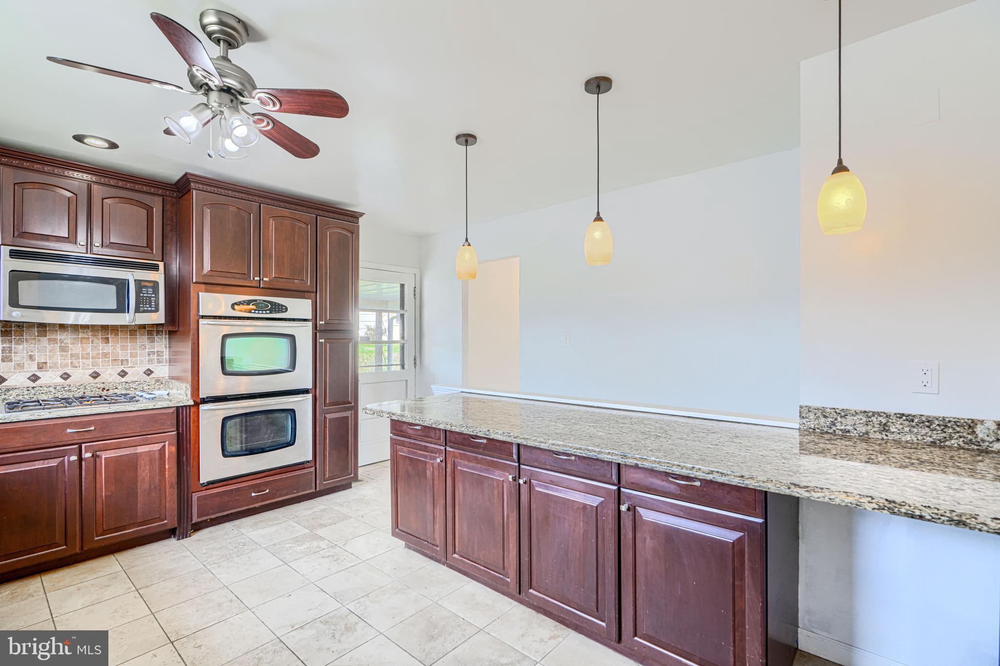 1741 Ellinwood Road Rosedale, MD 21237 - Photo 13 of 43 a kitchen with stainless steel appliances granite countertop a stove a sink and a microwave