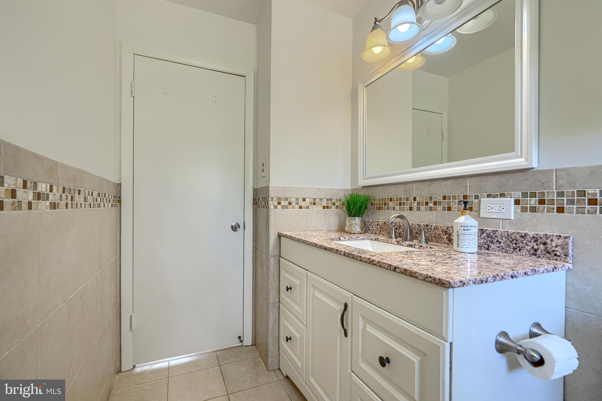 1741 Ellinwood Road Rosedale, MD 21237 - Photo 19 of 43 a bathroom with a granite countertop sink and a mirror