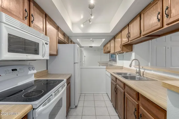 a kitchen with stainless steel appliances granite countertop a sink a stove and a refrigerator