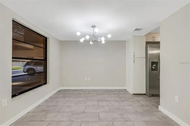 a view of a hallway with a chandelier and livingroom