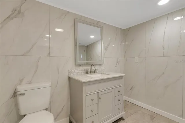 a bathroom with a granite countertop sink a toilet and a mirror