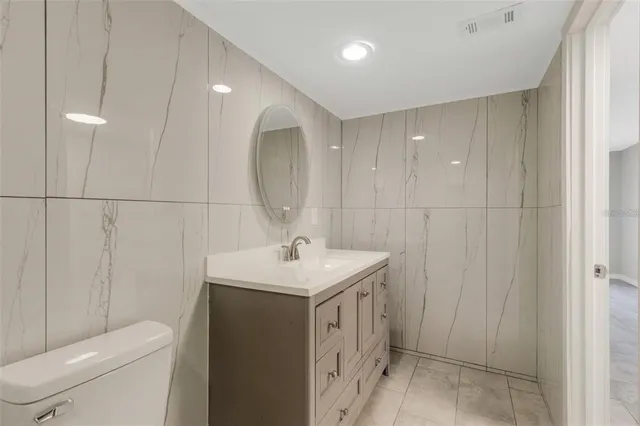 a bathroom with a sink a toilet and a mirror