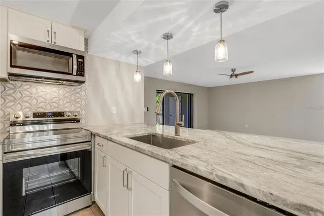a kitchen with stainless steel appliances granite countertop a sink and a stove