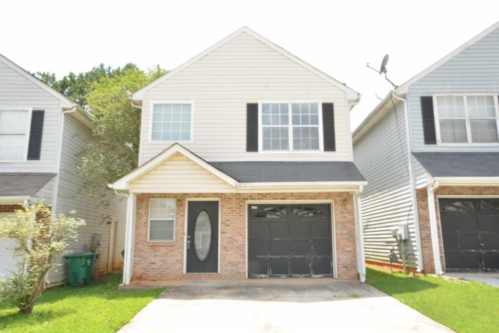 a front view of a house with a yard and garage